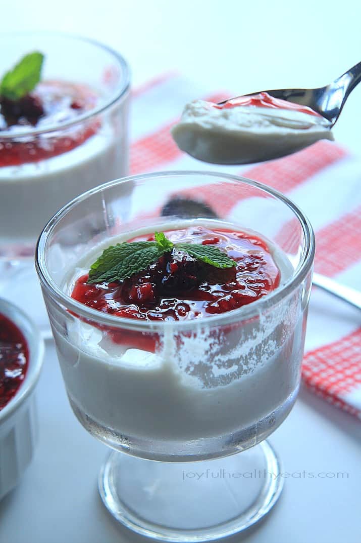 A spoonful and dessert glass of Coconut Panna Cotta topped with Raspberry Blackberry Compote