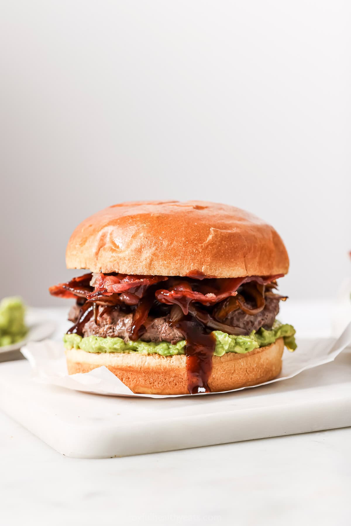 These Cowboy Hamburger Sliders are topped with creamy avocado, balsamic caramelized onions, and crispy bacon. Always a crowd-pleaser! Lightened up cowboy hamburger slider with barbecue sauce