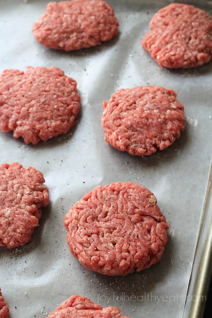 Top view of 6 raw slider burgers on parchment paper