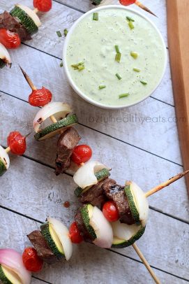 Grilled beef kabobs with a bowl of avocado cucumber tzatziki