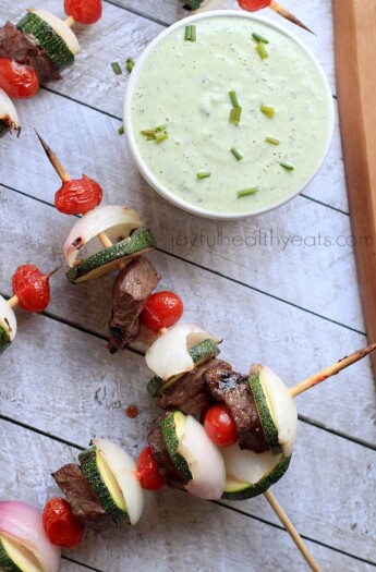 Grilled beef kabobs with a bowl of avocado cucumber tzatziki