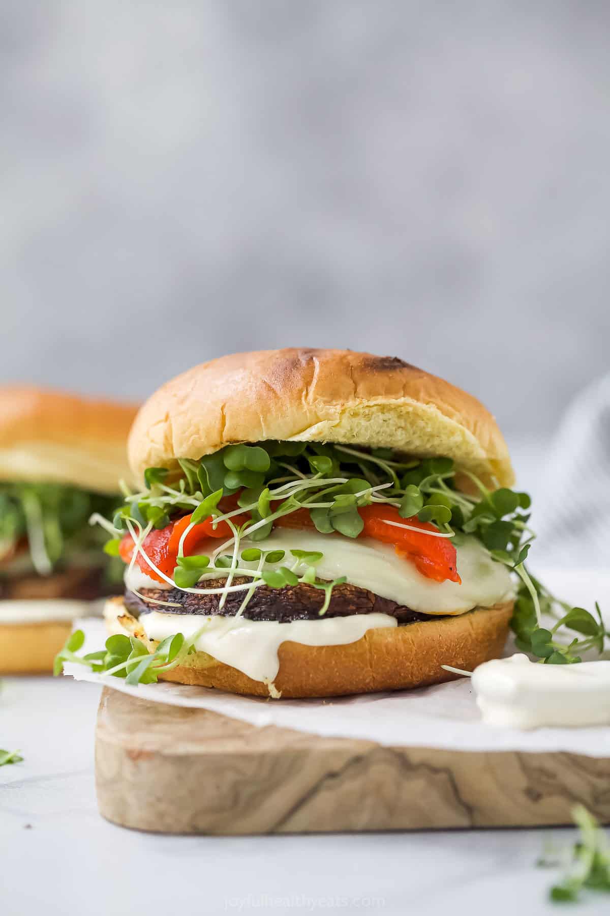 Melti provolone, roasted red pepper and creamy trafle IOli, it can only be the best portobelo mushroom sandwich! Grilled Portobelo Mushroom Sandwich on Wooden Boards