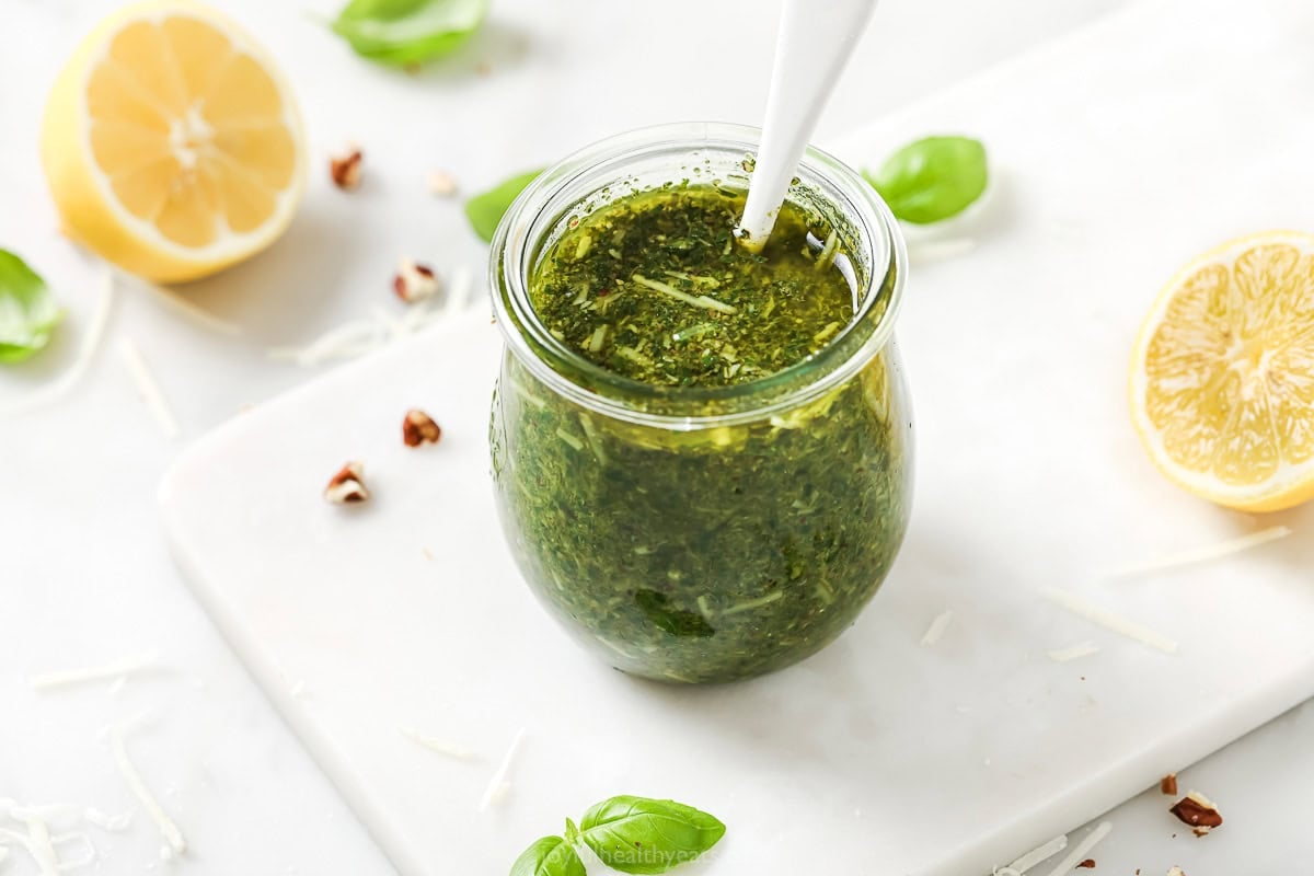 This Homemade Basil Pesto recipe is made with pecans instead of pine nuts to give it some extra body. It's my favorite way to make pesto! Spoon in jar of homemade basil pesto