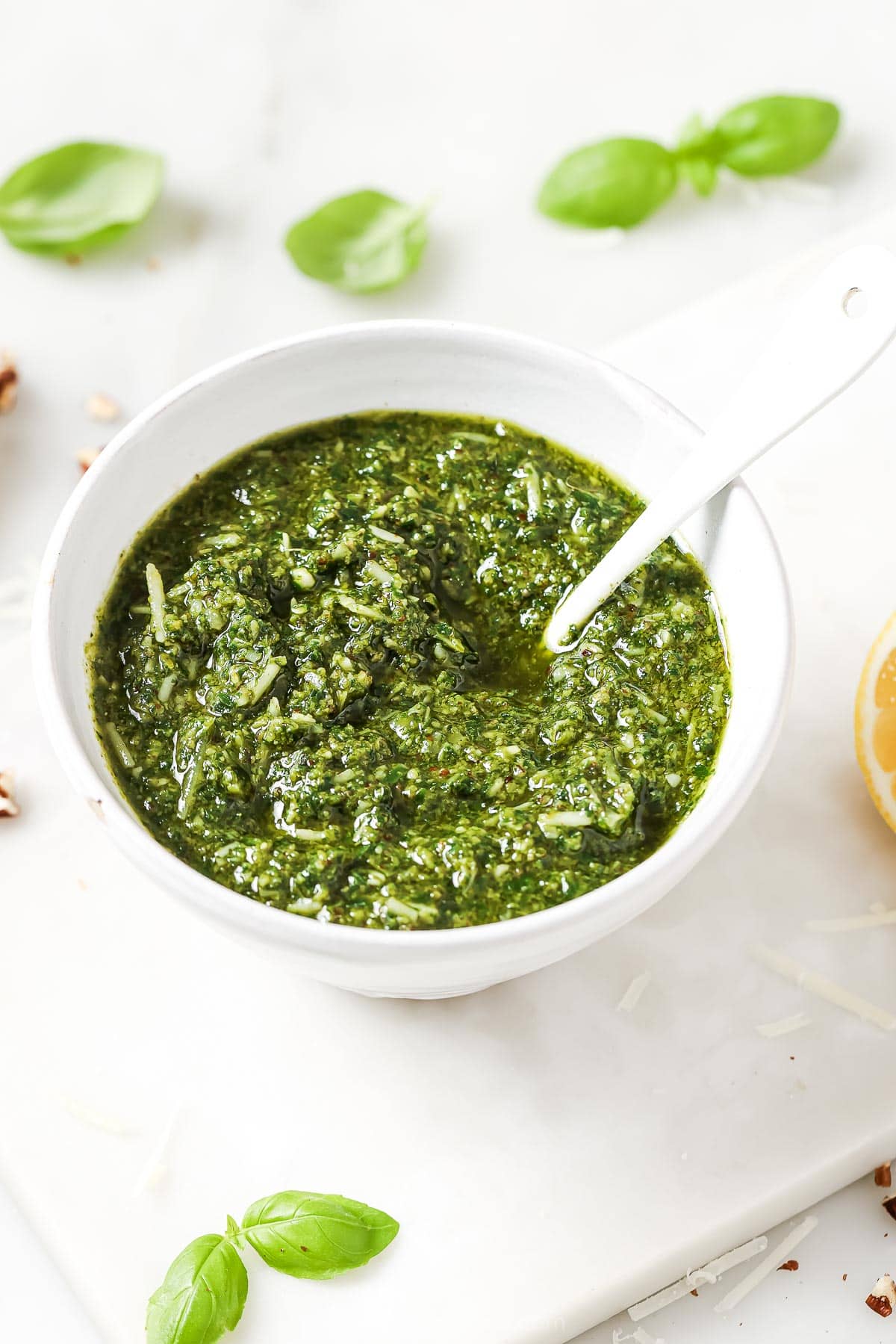 This Homemade Basil Pesto recipe is made with pecans instead of pine nuts to give it some extra body. It's my favorite way to make pesto! Bowl of homemade basil pesto with spoon