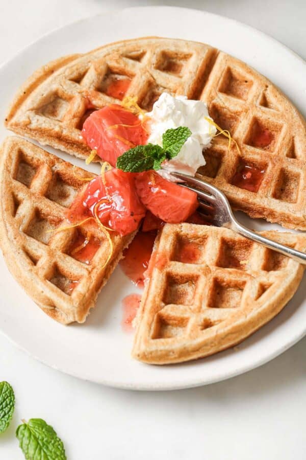 Crispy oatmeal waffle with strawberry compote and whipped cream