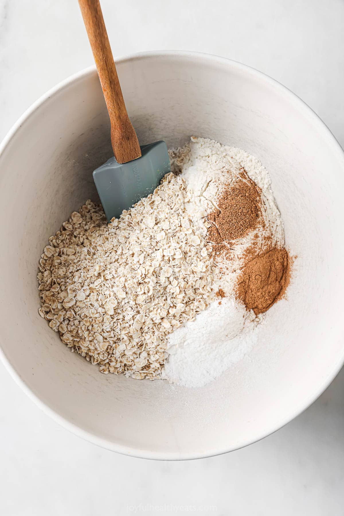 Overhead view of dry ingredients for oatmeal waffles in bowl before mixing