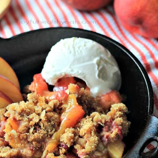 A sweet homemade Raspberry Peach Cobbler for two made with fresh raspberries, peaches, and hints of cinnamon topped with an Crunchy Oatmeal Pecan Crumble. | joyfulhealthyeats.com #recipes