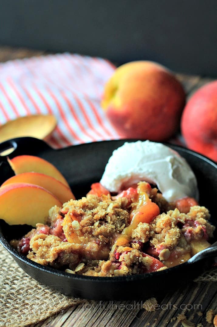 A sweet homemade Raspberry Peach Cobbler for two made with fresh raspberries, peaches, and hints of cinnamon topped with an Crunchy Oatmeal Pecan Crumble. | joyfulhealthyeats.com #recipes