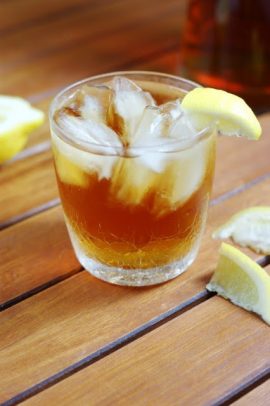 A glass of Southern Sweet Tea with ice and a lemon wedge