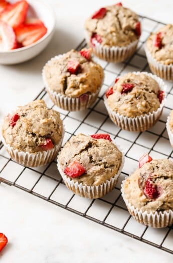 Fluffy strawberry banana muffins on a wire rack.