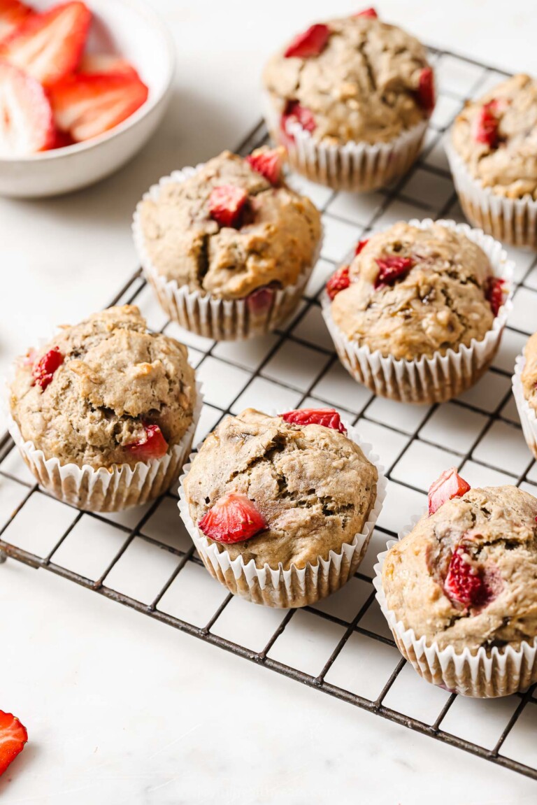 Fluffy strawberry banana muffins on a wire rack.