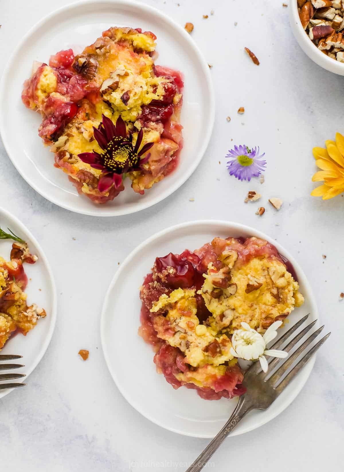 Servings of Cherry Pineapple Dump Cake on plates with decorative wildflowers