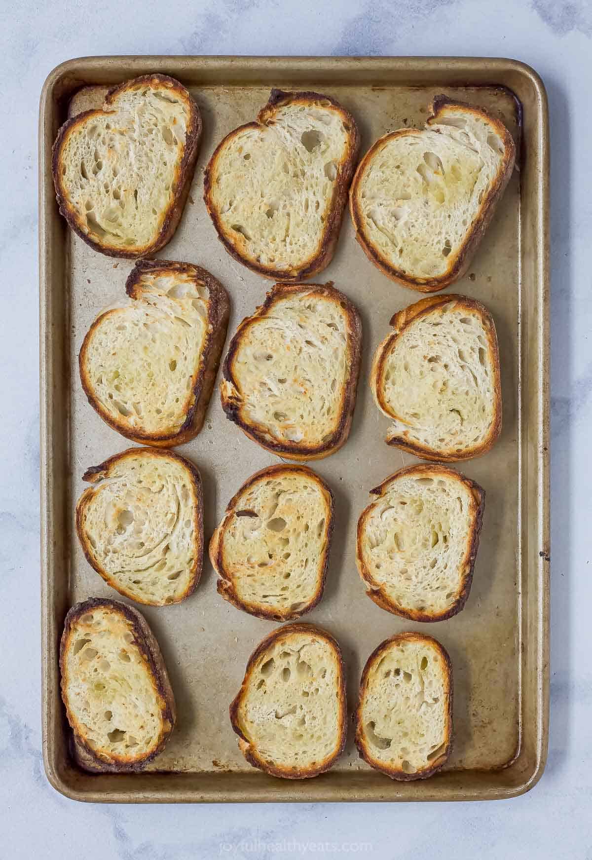 Overhead view of bread slices on baking sheet