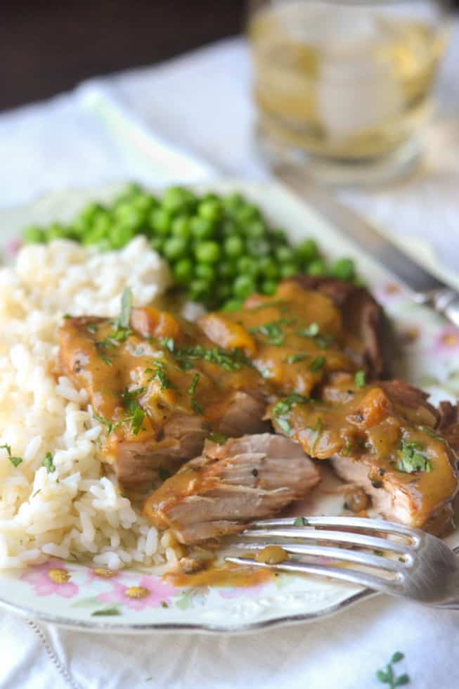 Slow Cooker Peach BBQ Smothered Pork Chops on a Plate with Rice and Peas