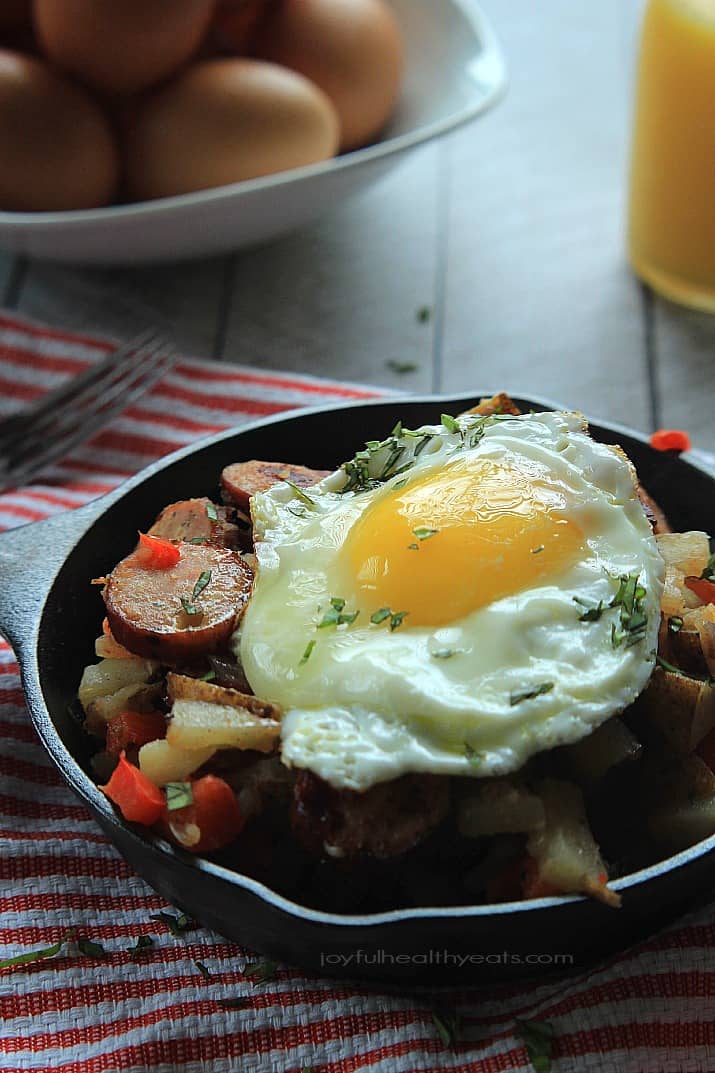 Chicken Sausage Potato Hash in a cast-iron skillet topped with a fried egg