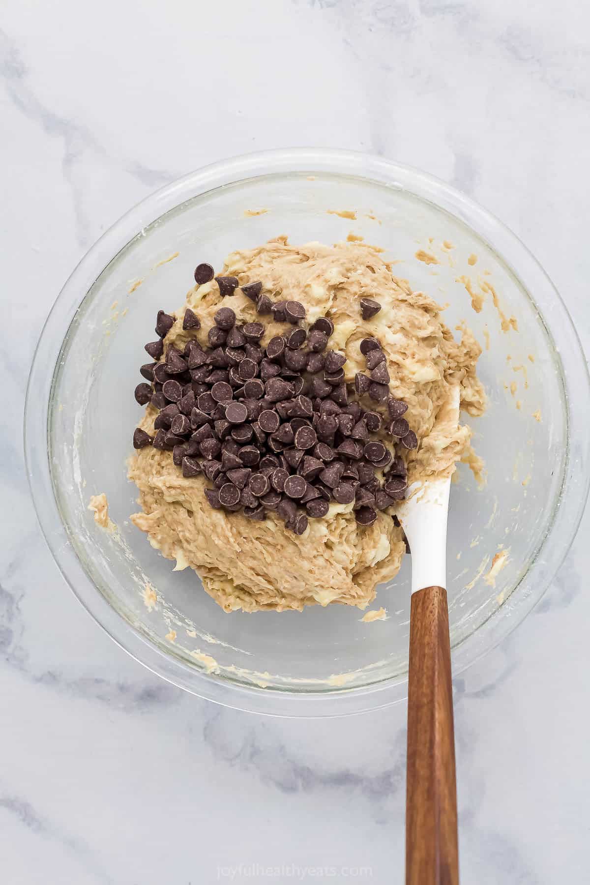 Banana bread batter with chocolate chips in a bowl.