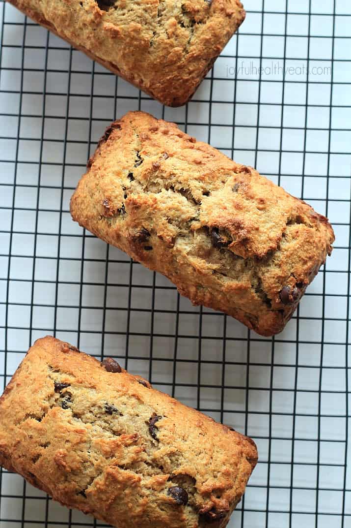 Top view of three loaves of Coconut Pecan Chocolate Chip Banana Bread on a cooling rack