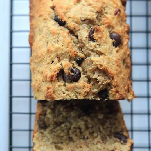 A Loaf of Coconut Pecan Chocolate Chip Banana Bread on a Cooling Rack