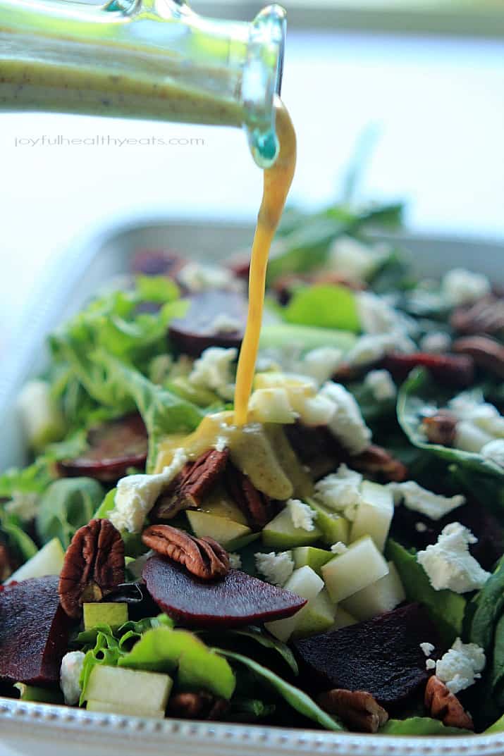 Honey Mustard Vinaigrette being poured over Goat Cheese Asian Pear & Beet Salad