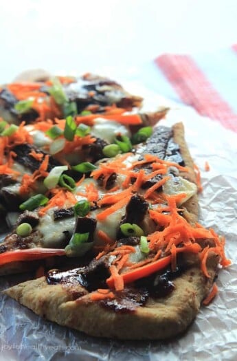 A Grilled Pizza Topped with Veggies on a Piece of Crinkly Wax Paper