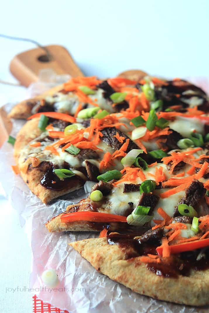 A Grilled Short Rib Flatbread on a Wooden Surface Covered in Wax Paper