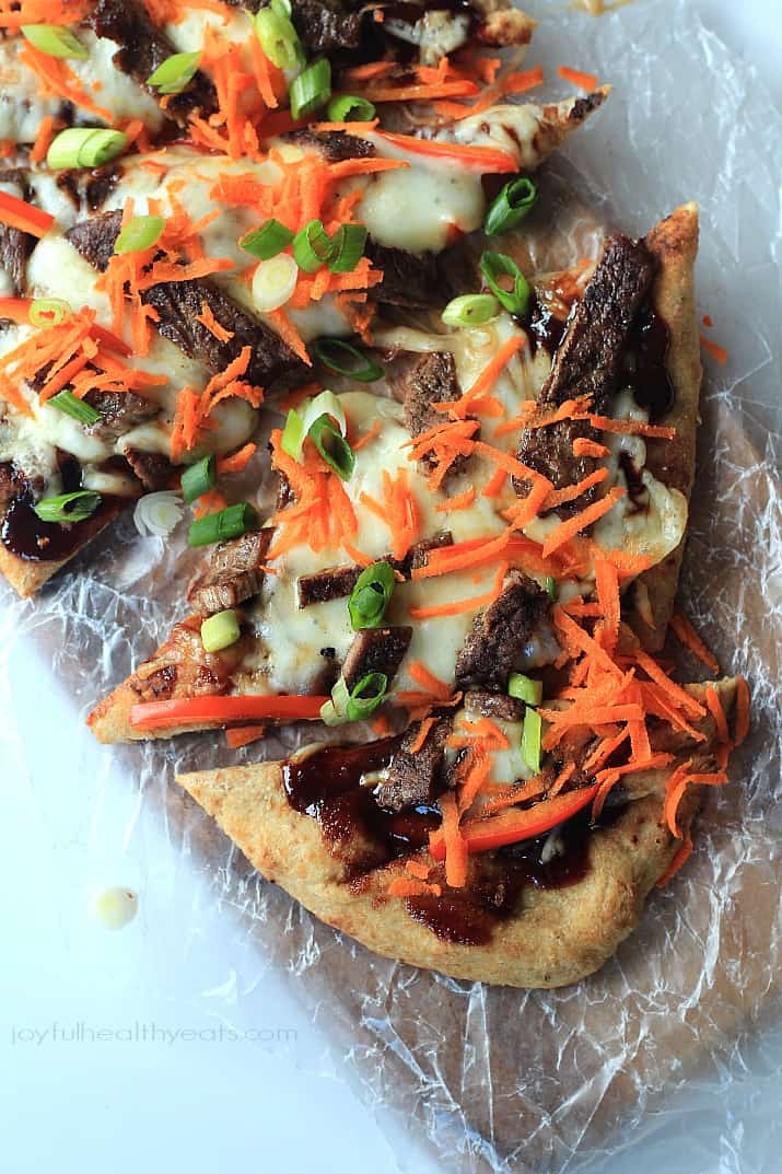 Four Slices of Short Rib Pizza Topped with Shredded Carrots