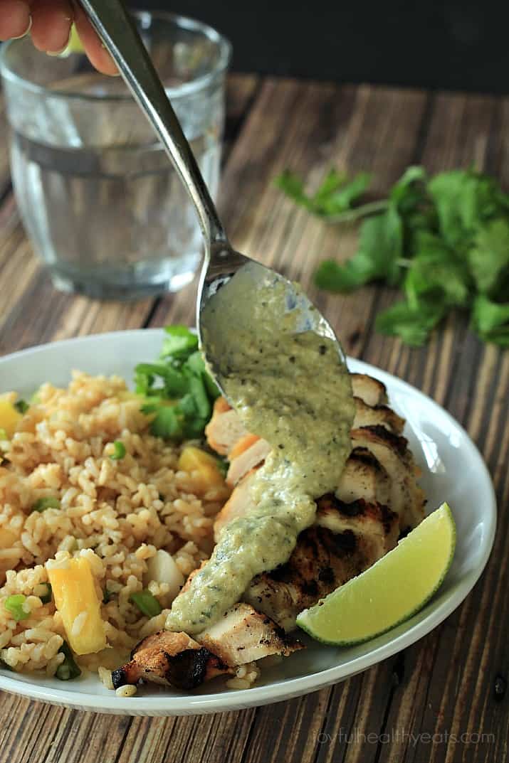 Poblano Cream Sauce being drizzled over Grilled Sliced Chicken on a plate