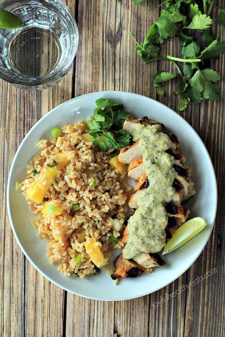 Top view of Grilled Chicken with Tomatillo Sauce and pineapple rice on a plate