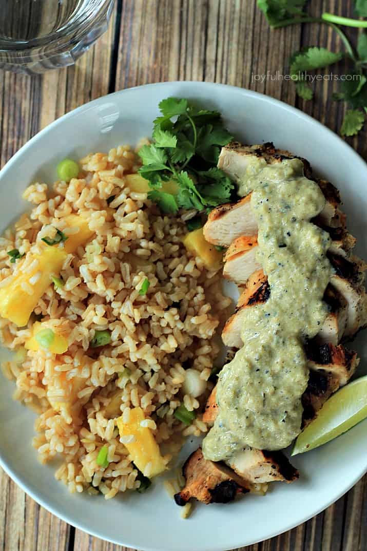 Top view of Grilled Chicken with Tomatillo Roasted Poblano Cream Sauce and pineapple rice on a plate