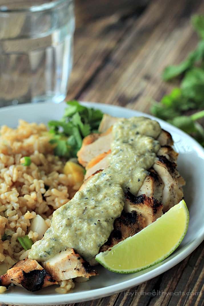 Close-up of Grilled Chicken with Tomatillo Roasted Poblano Cream Sauce and pineapple rice on a plate