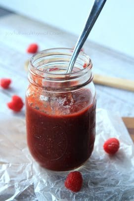 Raspberry Chipotle BBQ Sauce in a Glass Jar Next to Five Raspberries