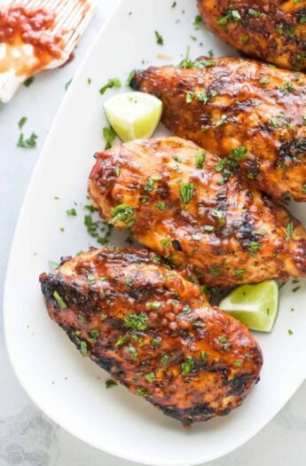 Grilled chicken with sweet-and-savory BBQ sauce, fresh cilantro, and lime wedges.
