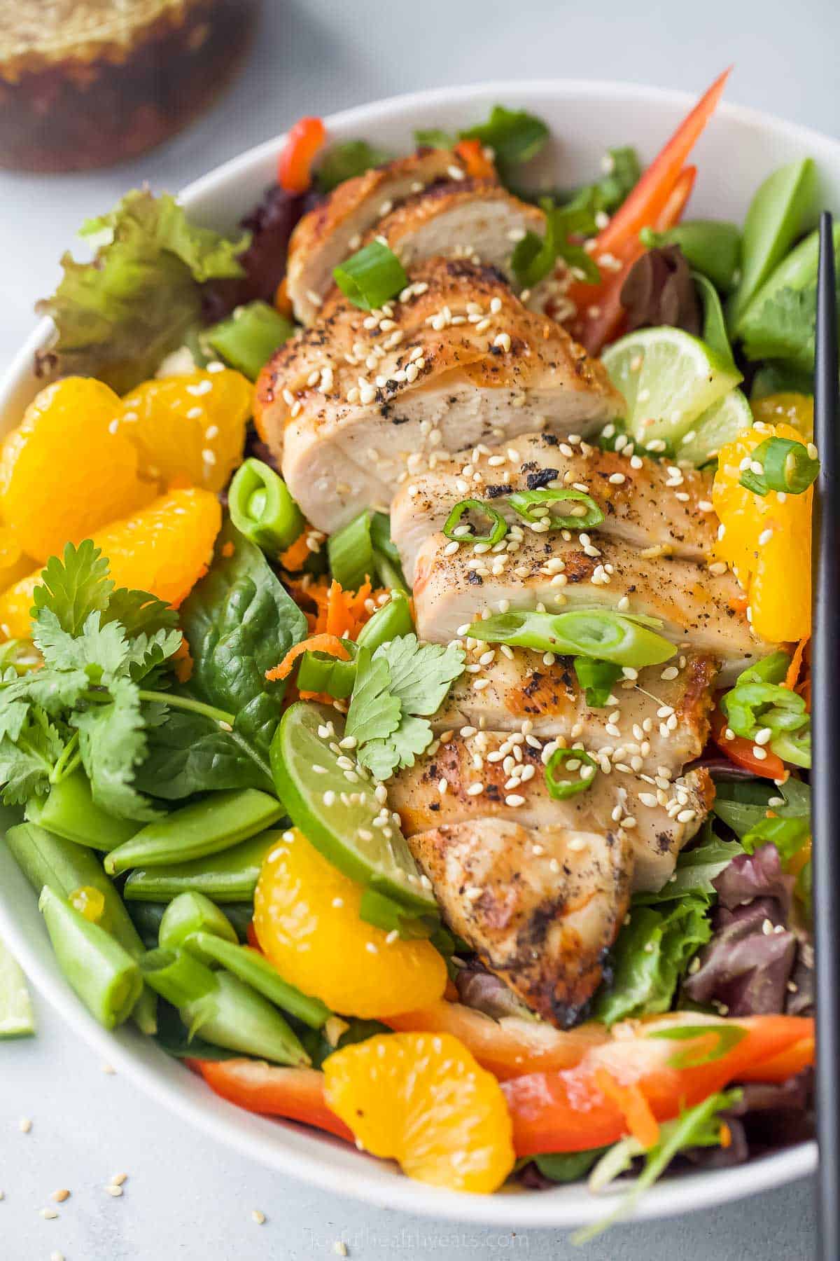 Bowl of Asian chicken salad with mandarin oranges, snow peas, and more.