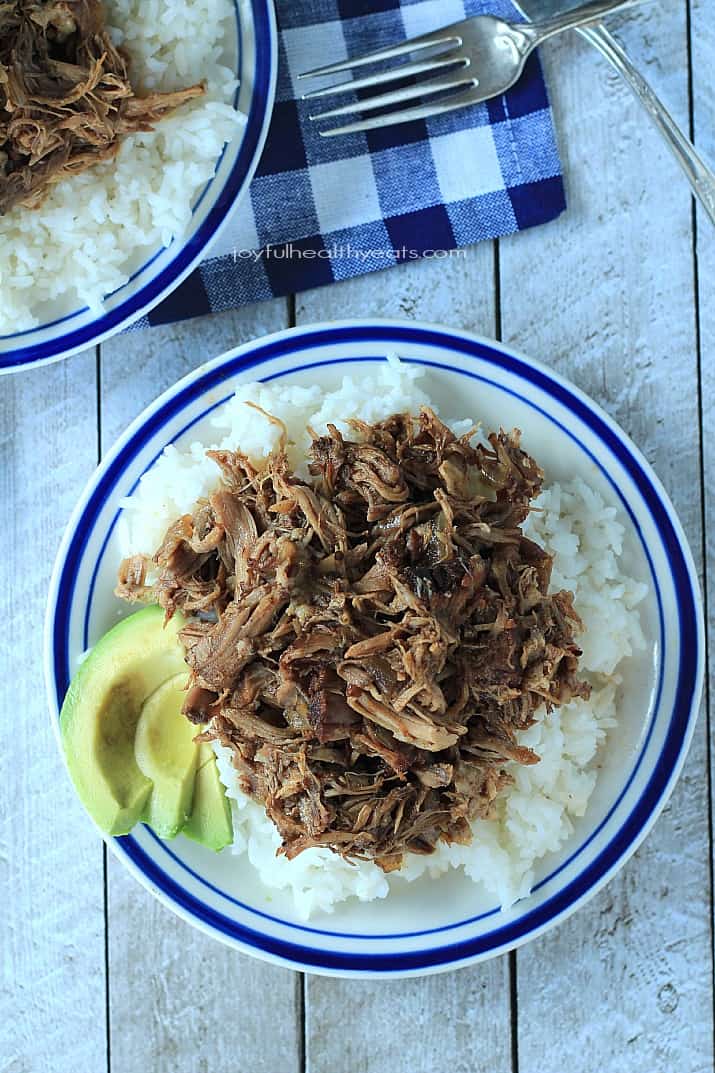 Top view of Honey Balsamic Pulled Pork on a plate over rice with sliced avocado