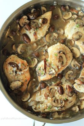 Chicken and mushrooms cooking in a pan with broth