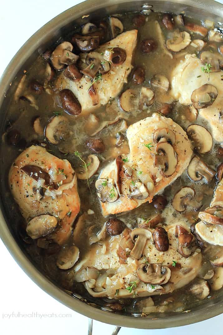 A pot filled with seared chicken and mushrooms