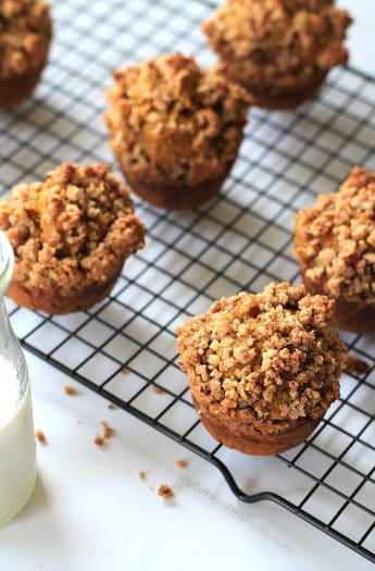 Pumpkin muffins on a wire cooling rack beside a glass of milk