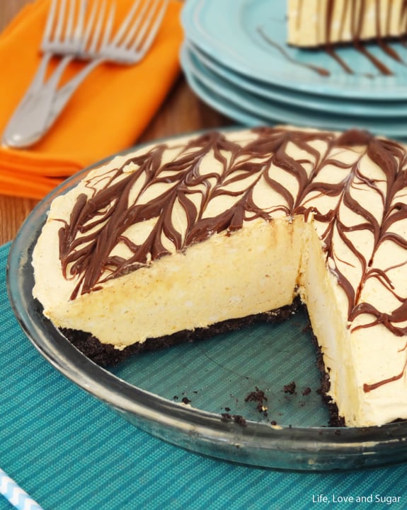 A Pumpkin Spice Nutella Ice Cream Pie in a Glass Dish with Two Pieces Missing