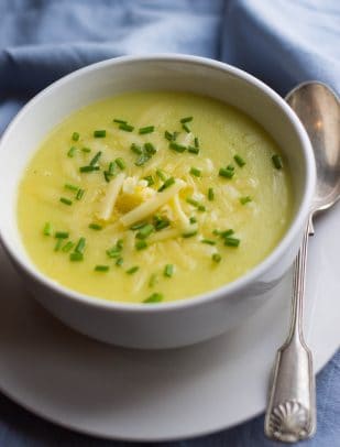A Bowl of Potato Leek Soup on a Plate with a Spoon