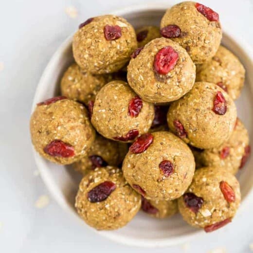 a bowl filled with pumpkin energy balls with cranberries