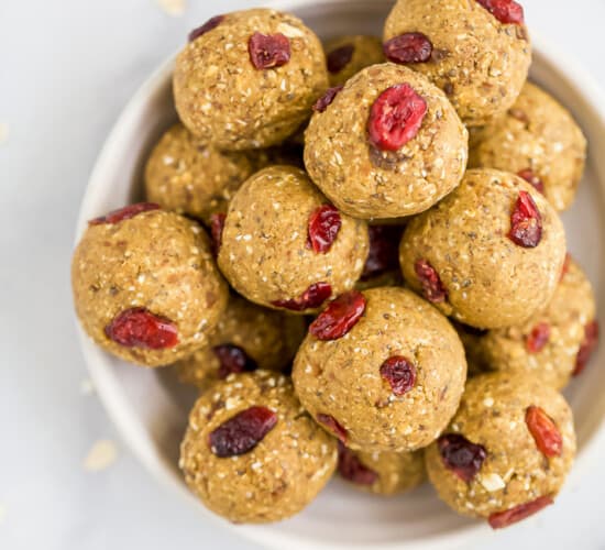 a bowl filled with pumpkin energy balls with cranberries