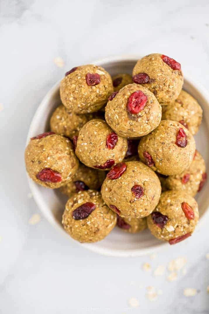 a bowl filled with pumpkin energy balls with cranberries