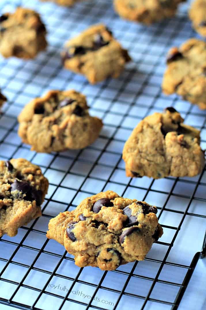 Freshly-baked cookies lined up on a wire rack on top of a white countertop