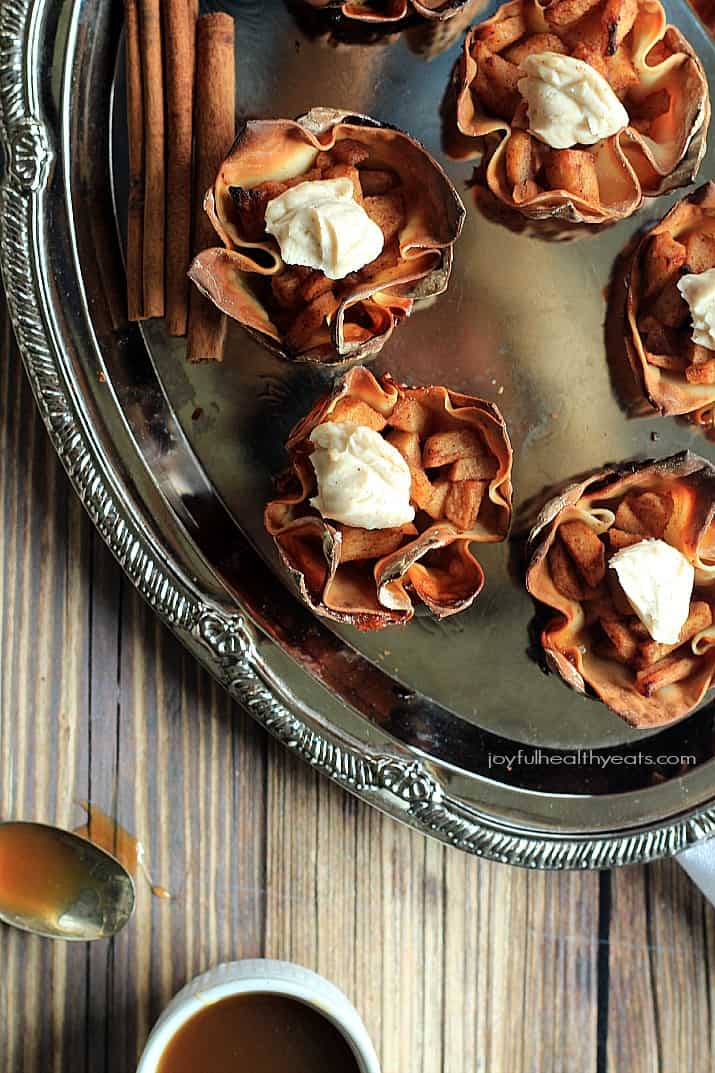 Top view of Caramel Apple Pie Wonton Cups with a Honey Cinnamon Mascarpone on a silver platter