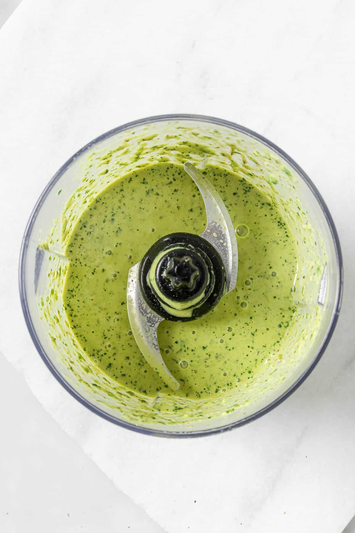 This hearty chicken Cobb salad is jazzed up with Tex-Mex flavors, from avocado and queso fresco to a creamy and tangy poblano dressing! Overhead view of creamy poblano dressing in food processor bowl