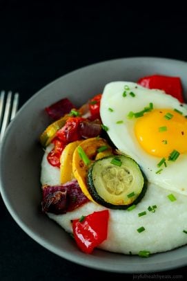 A Bowl of Goat Cheese Grits and Eggs in Front of a Black Background