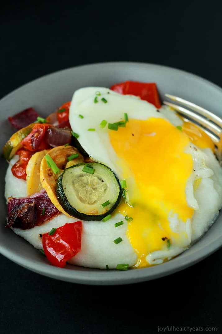 The Runny Yolk of an Egg with Grits and Veggies in a Bowl