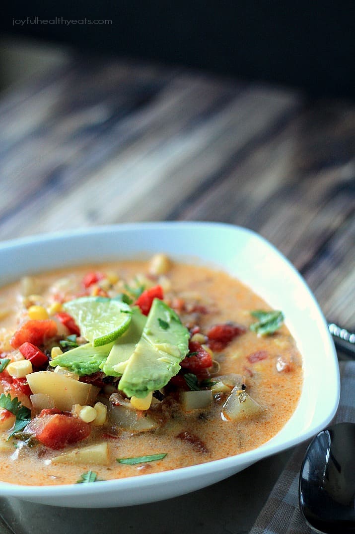 A bowl of Southwestern Corn & Potato Chowder topped with sliced avocado and lime