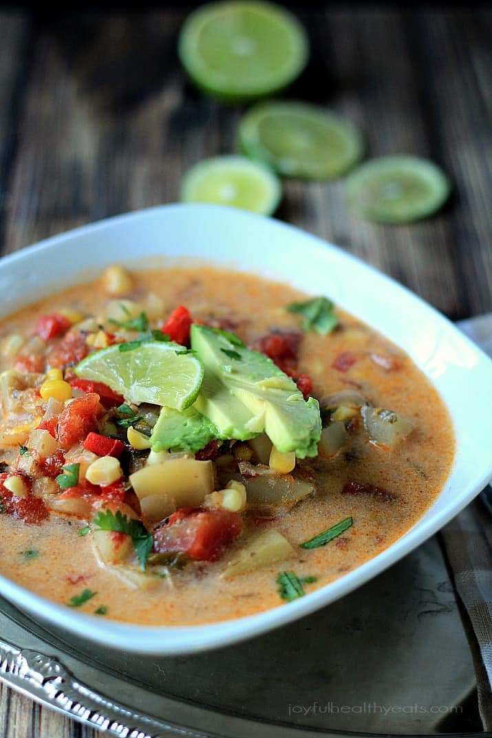 A bowl of Southwestern Corn & Potato Chowder topped with sliced avocado and lime