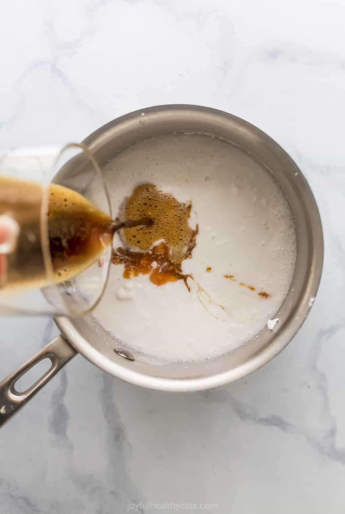 This dairy-free Espresso Ice Cream is full of coffee flavor and dotted with chocolate chips—because everything’s better with chocolate! Pouring espresso into pan of coconut milk